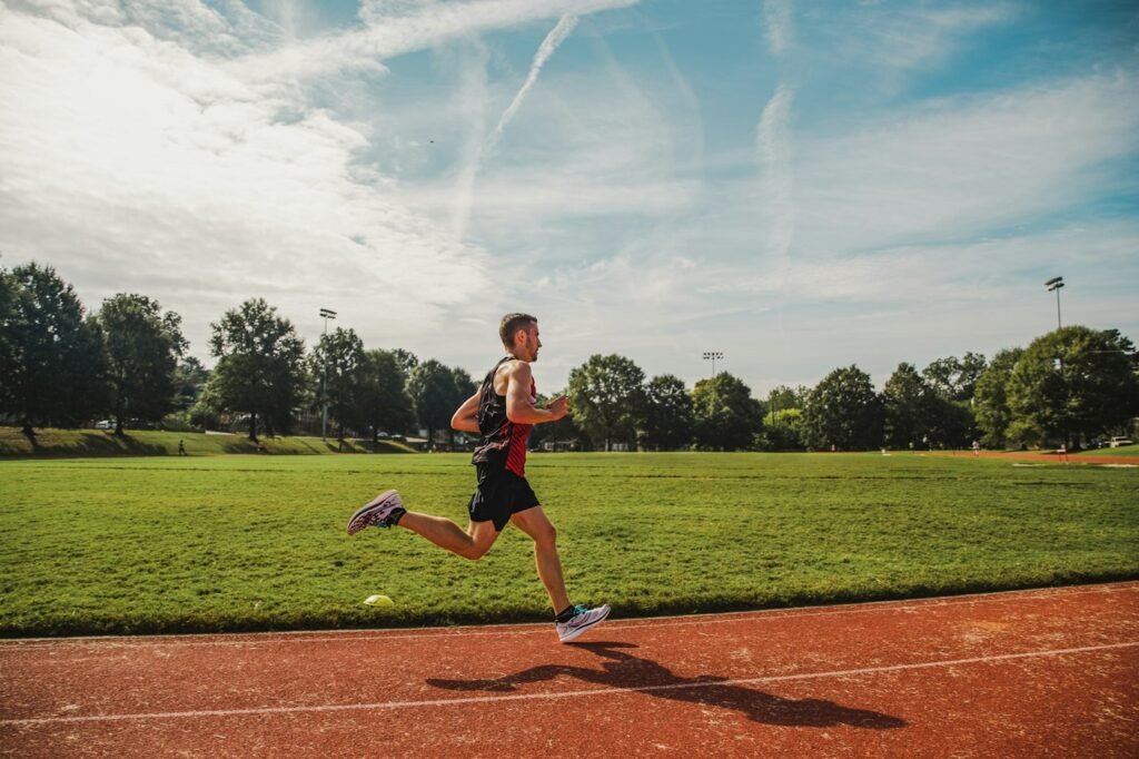 Homem correndo em uma pista de atletismo vermelha