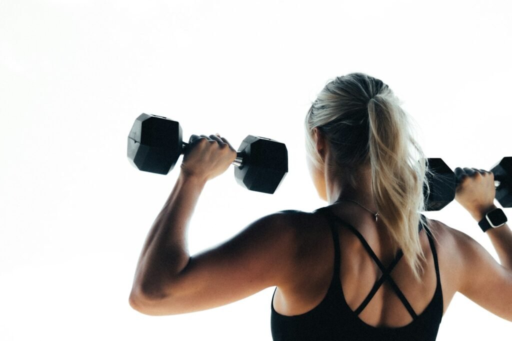 Mulher segurando halteres durante treino de força