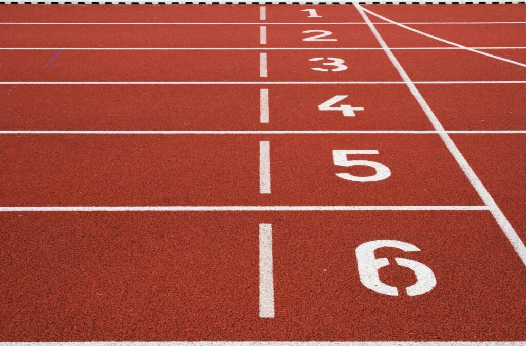 Raias numeradas de uma pista de atletismo vermelha