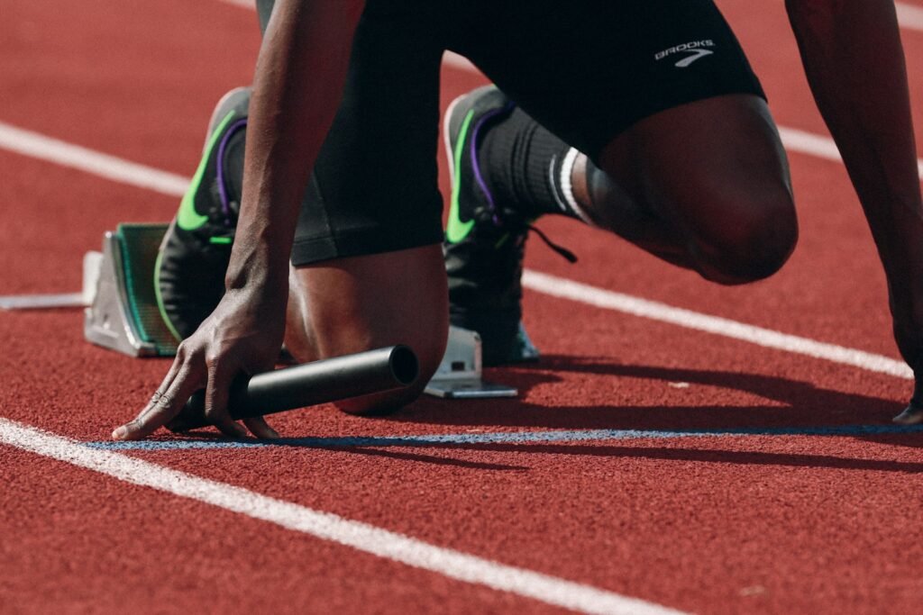 Corredor em pista de atletismo ao amanhecer